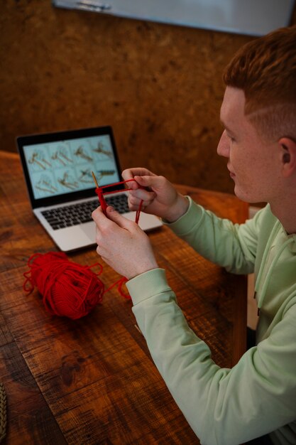 High angle man knitting at home