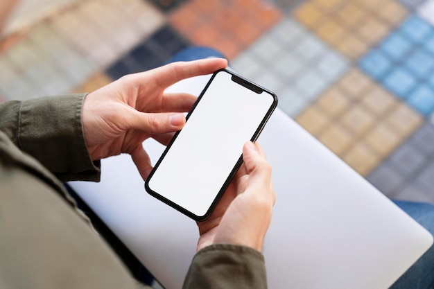 Free photo high angle man looking at his phone with empty screen