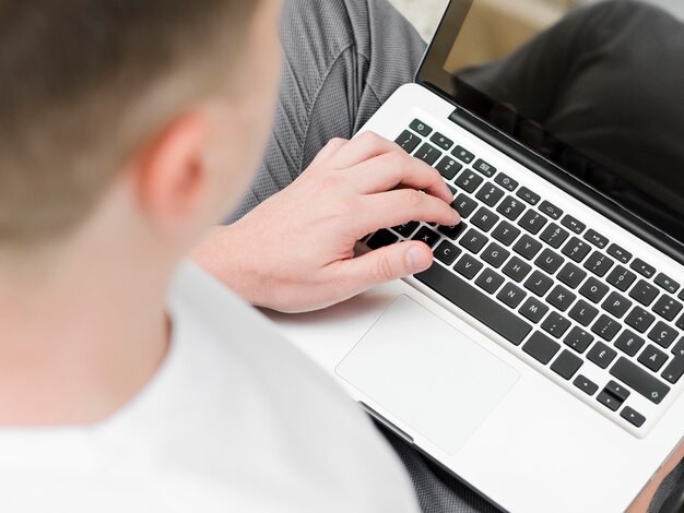 High angle of man working on laptop outdoors