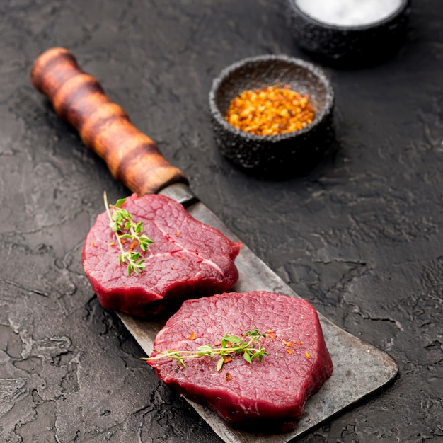 Free photo high angle of meat on cleaver with spices and herbs