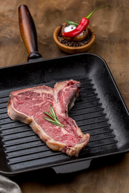 Free Photo high angle of meat in pan with herbs and chili