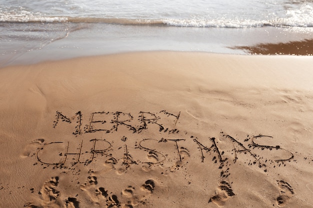 Free Photo high angle merry christmas message in sand