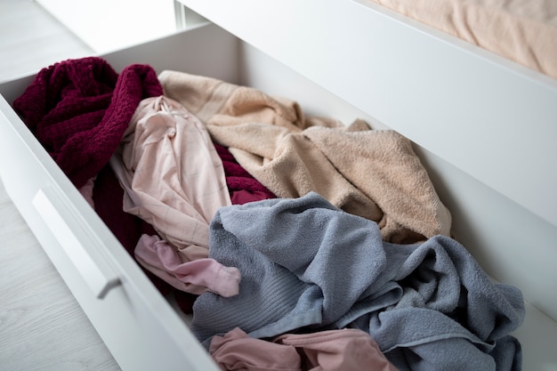 Free photo high angle messy drawer with clothes