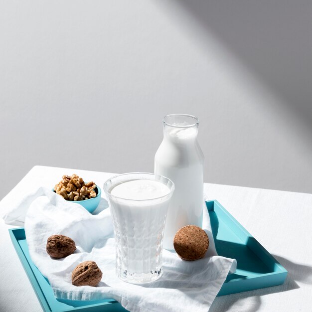 High angle of milk bottle and glass with walnuts