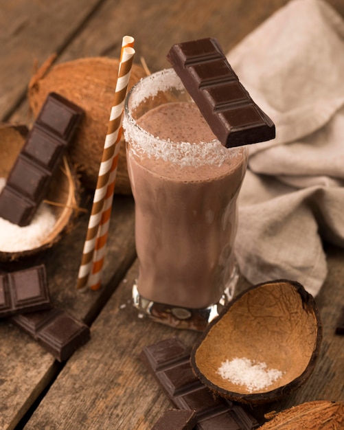 High angle of milkshake glass on tray with chocolate coconut