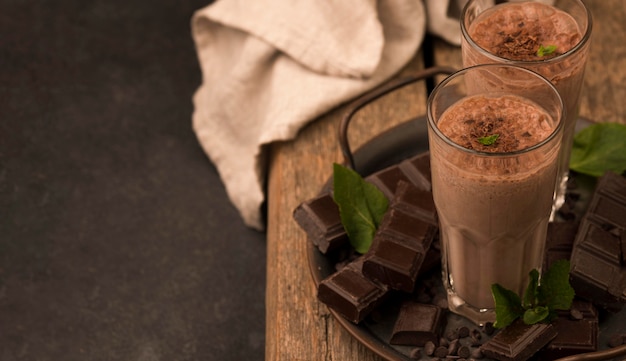 High angle of milkshake glasses on tray with mint and copy space