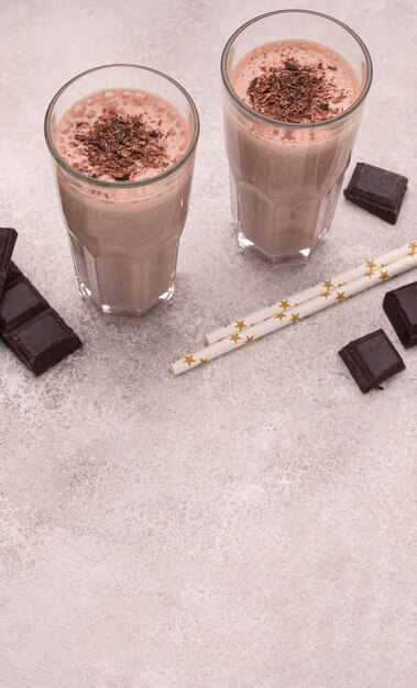 High angle of milkshake glasses with chocolate and copy space