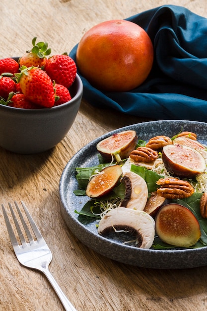 High angle mix of figs and nuts on plate with strawberries