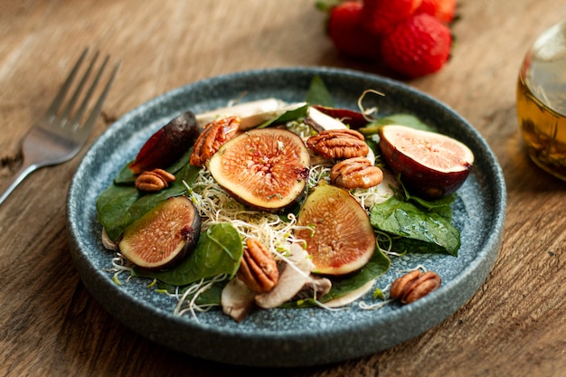 Free photo high angle mix of nuts and figs on plate with strawberries