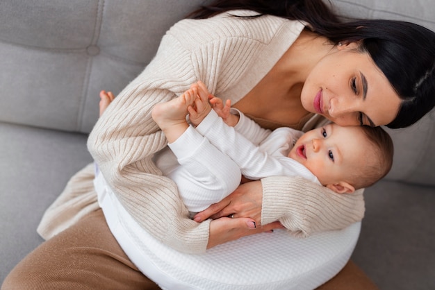 Free photo high angle mother holding newborn baby