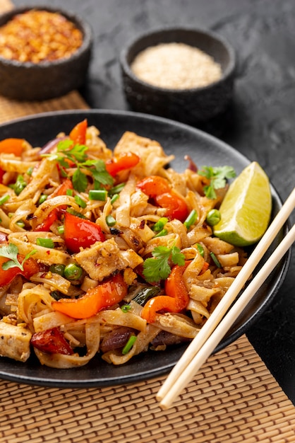 High angle noodles with vegetables and chicken with chopsticks