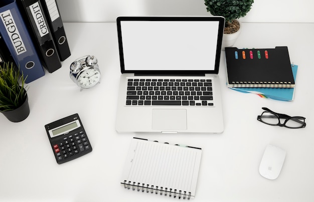 High angle of office desk surface with laptop and notebook