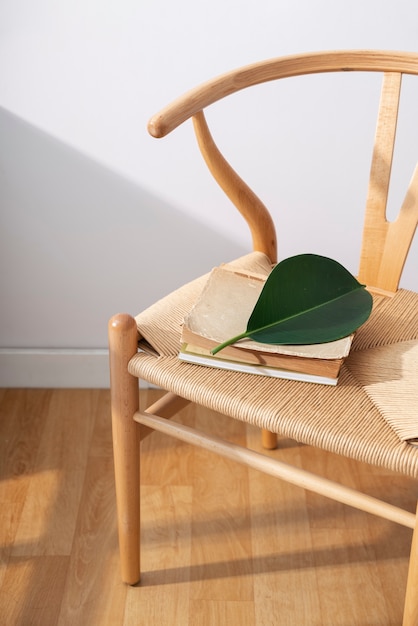 Free photo high angle old books and leaf on chair