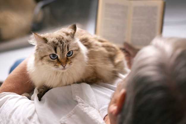 Free Photo high angle old man holding cat