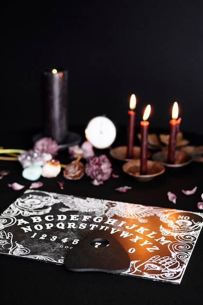 Free photo high angle old ouija board and candles arrangement