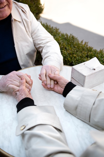 Free photo high angle old people holding hands