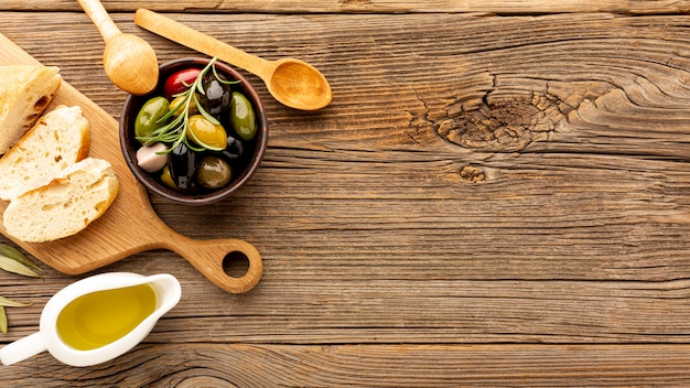 High angle olives mix bread and oil bottles with copy space