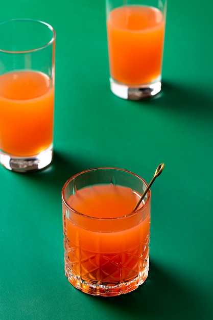 High angle orange drinks on green background