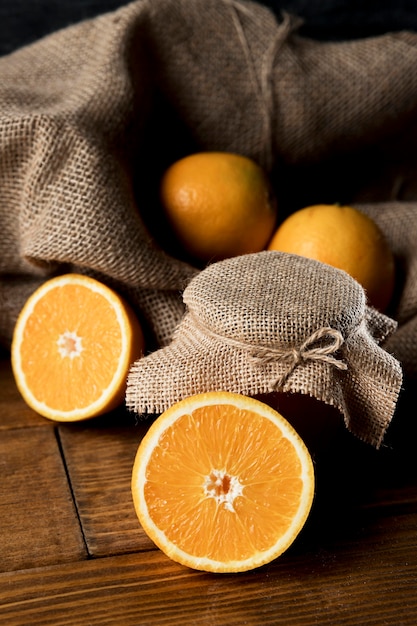 Free photo high angle of oranges with burlap and marmalade jar