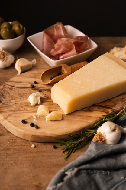 High angle parmesan and prosciutto on cutting board