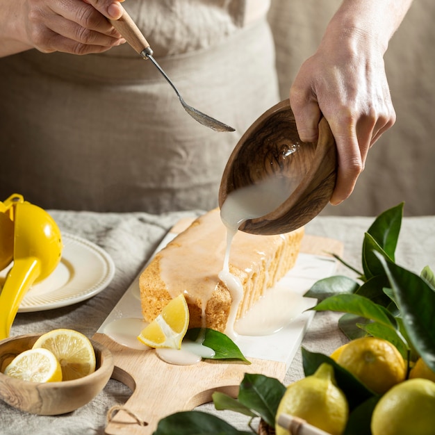 Free photo high angle of pastry chef adding topping to lemon cake