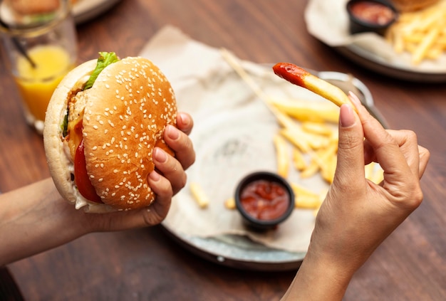 High angle of person eating burger and french fries