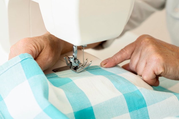 High angle of person using sewing machine and textile