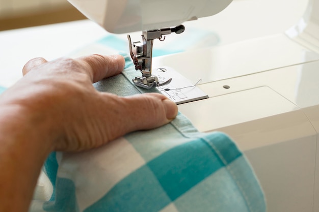 Free photo high angle of person using sewing machine