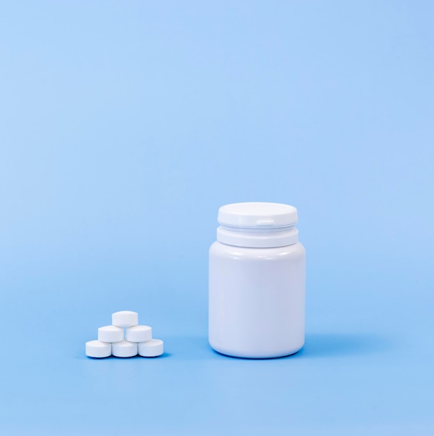 High angle of pills and plastic container