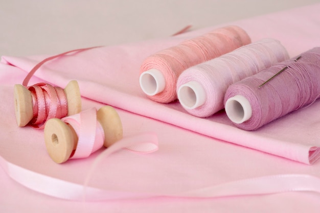 Free Photo high angle of pink thread rolls with fabric