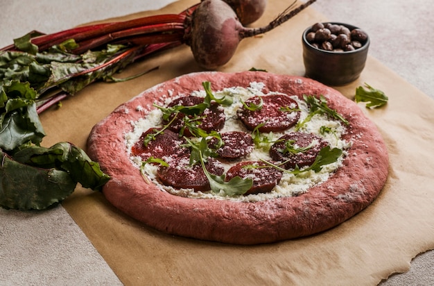 Free photo high angle of pizza dough with beet slices and cheese