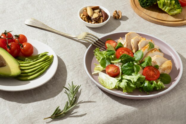 High angle of plate with keto diet food and a plate with sliced avocado