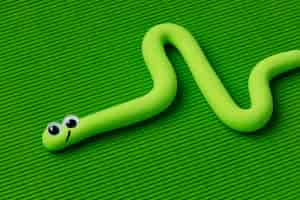 Free photo high angle play dough snake with green background