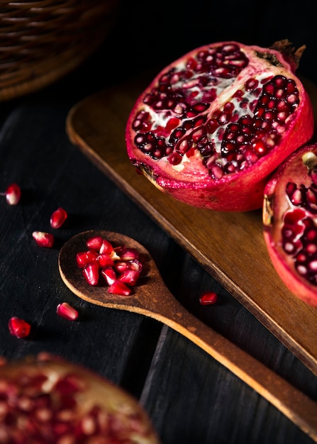 Free photo high angle of pomegranate fruit with wooden spoon