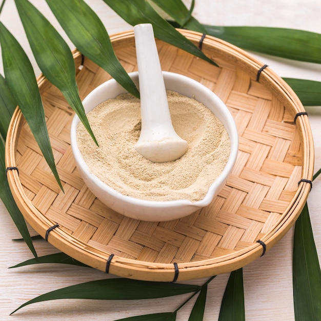 High angle of powder in bowl with leaves and pestle