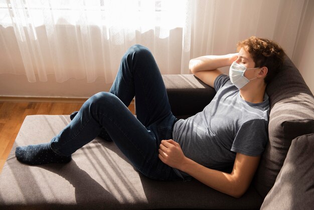 High angle quarantined boy sitting on the sofa