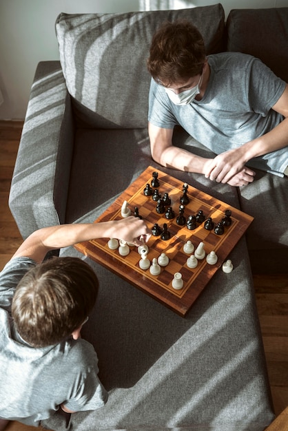 Free Photo high angle quarantined boys playing chess