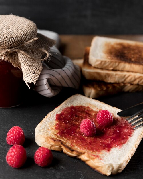 Free photo high angle of raspberry jam on bread with jar