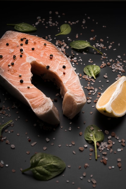 High angle raw salmon steak with pepper and lemon