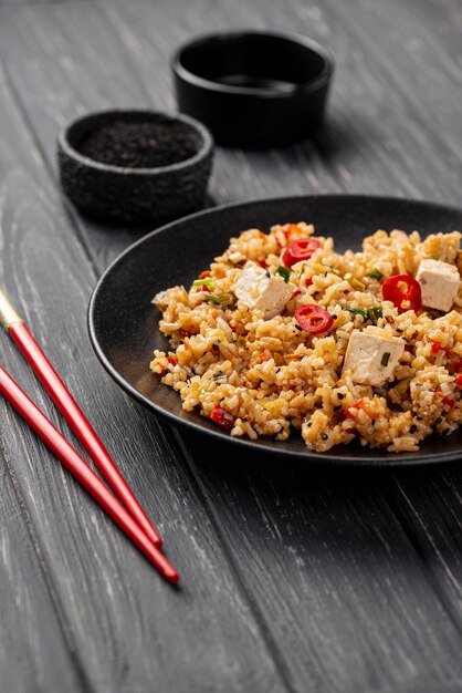 High angle rice with vegetables on plate and chopsticks with copy space