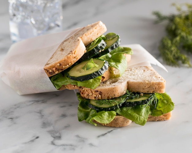 Free Photo high angle of sandwiches with greens and cucumber