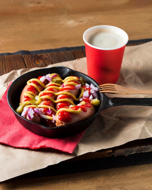 High angle sausages in pan with sauces and onion