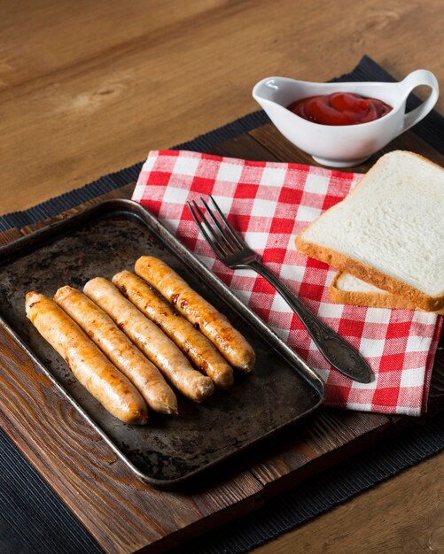 High angle sausages on tray with bread