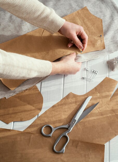 High angle of seamstress with fabrics and scissors