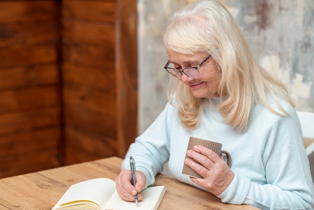 High angle senior female writing on agenda