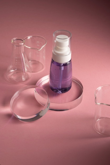 Free photo high angle serum bottle and lab glasses