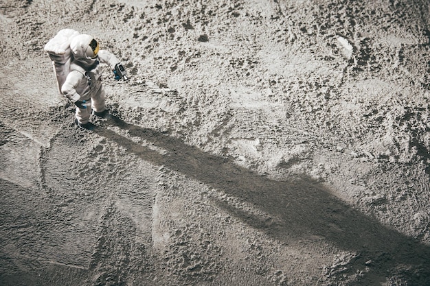 Free photo high angle shot of an astronaut miniature toy on the moon