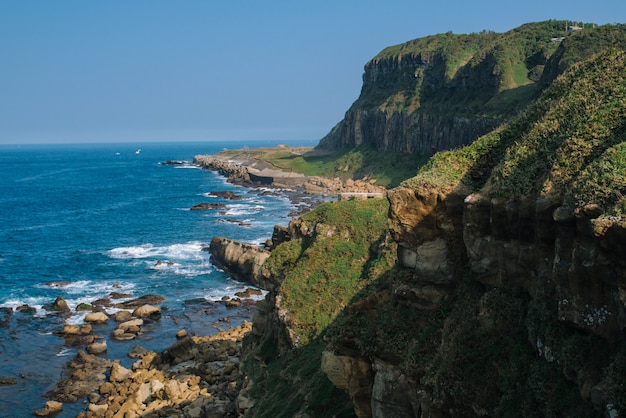 High angle shot of a beautiful cliff covered with moss near the sea