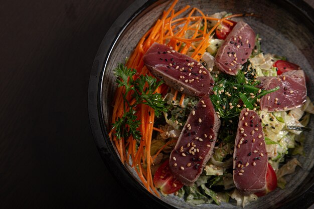 High angle shot of a bowl of traditional Asian food on a black surface