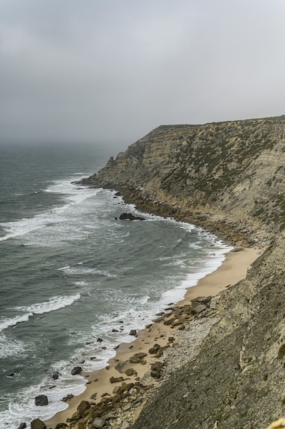 High angle shot of a cliff near the sea under a gloomy weather